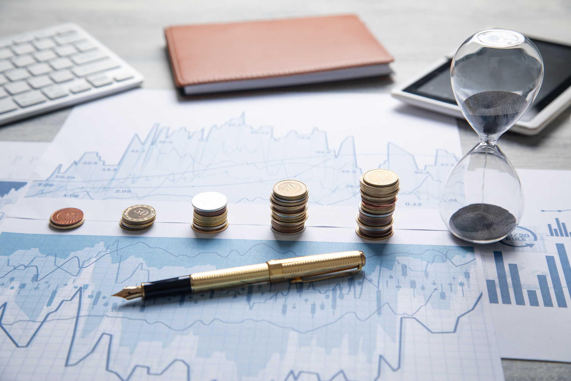 Patrimoine financier interprété par une évolution croissante d'une pile de pièce avec un sablier